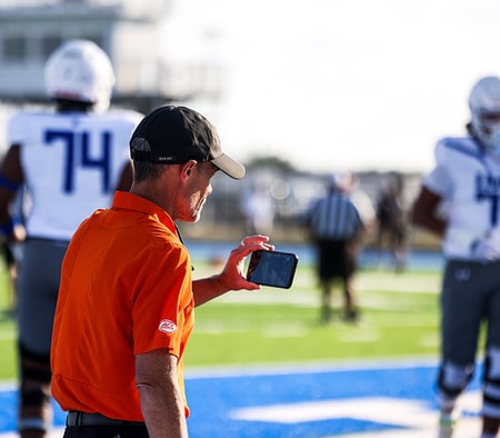 College coach using his phone College coach using his phone